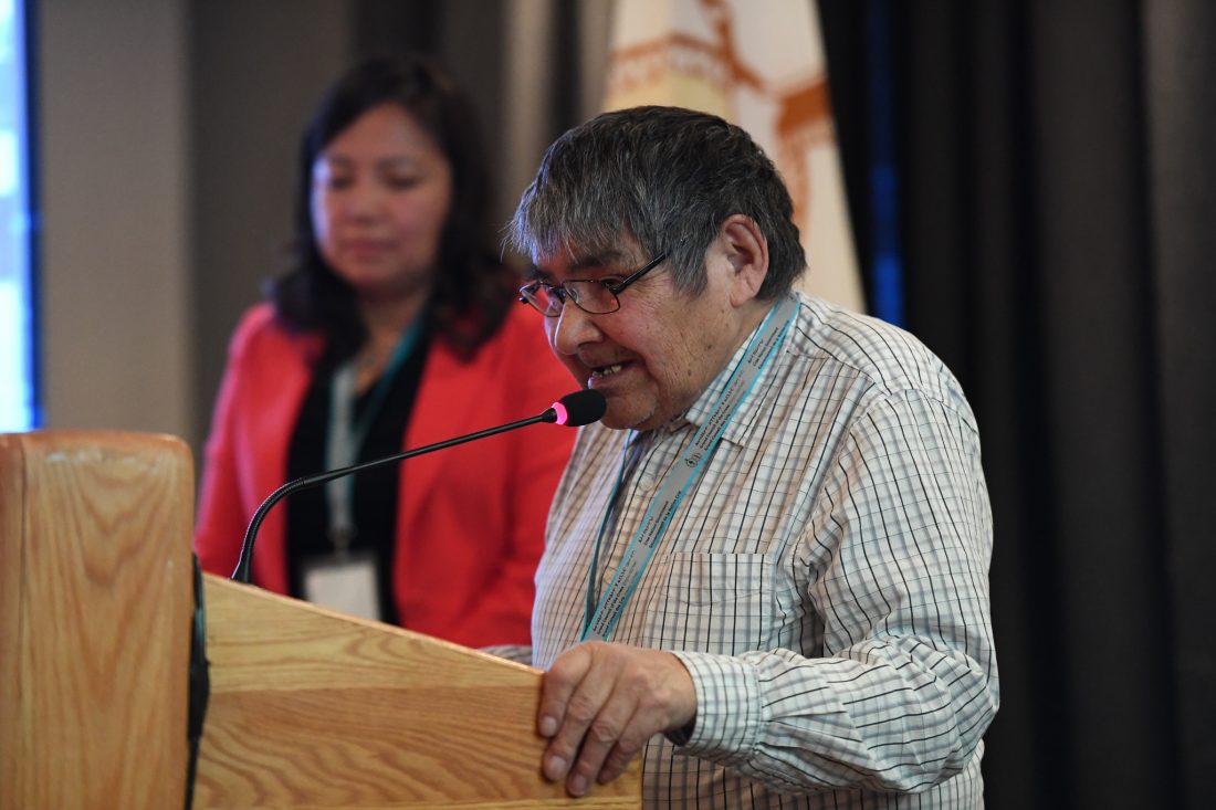 Elderly man speaking at a podium